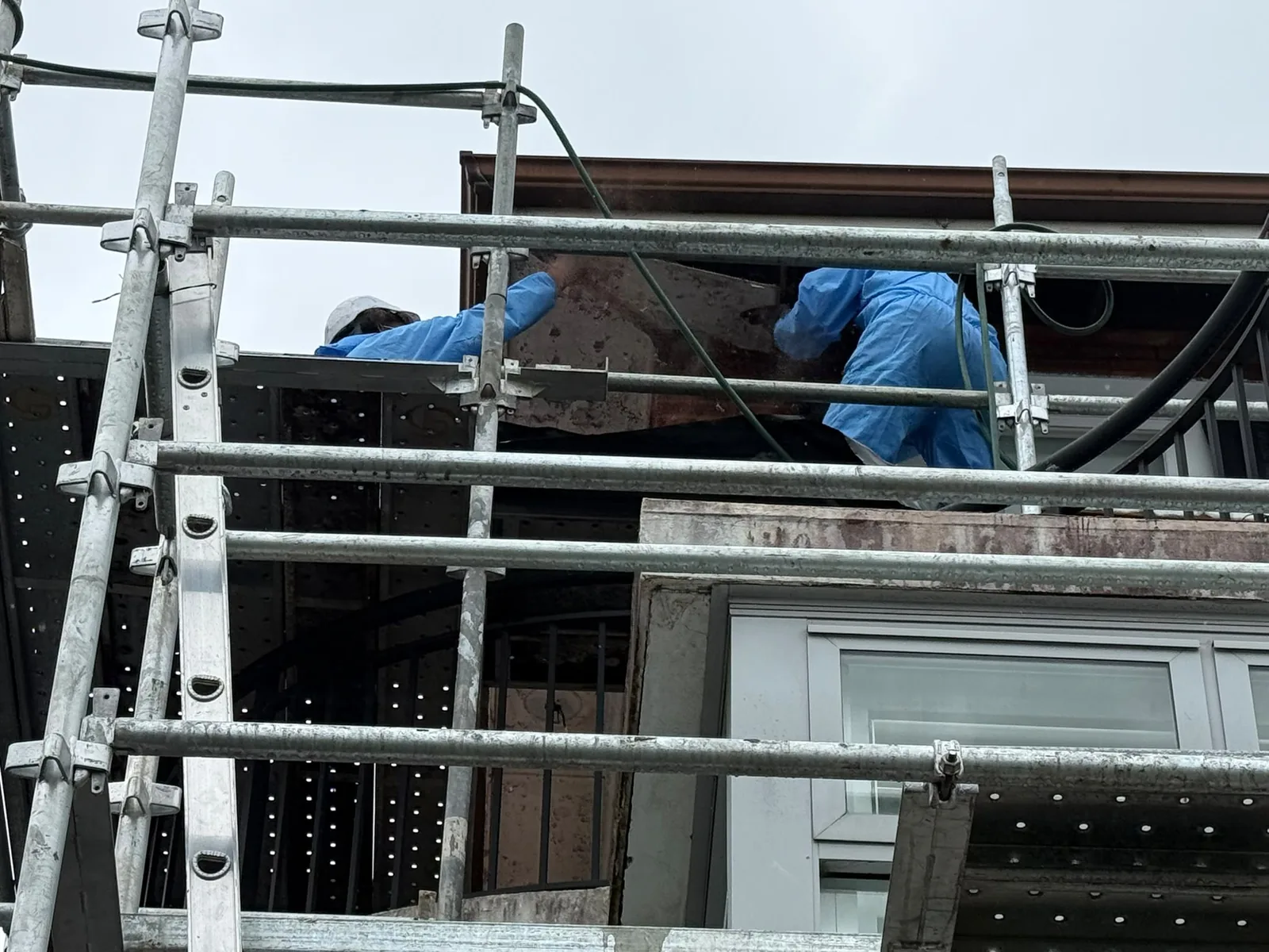 Licensed removalists working from scaffold at a residential project